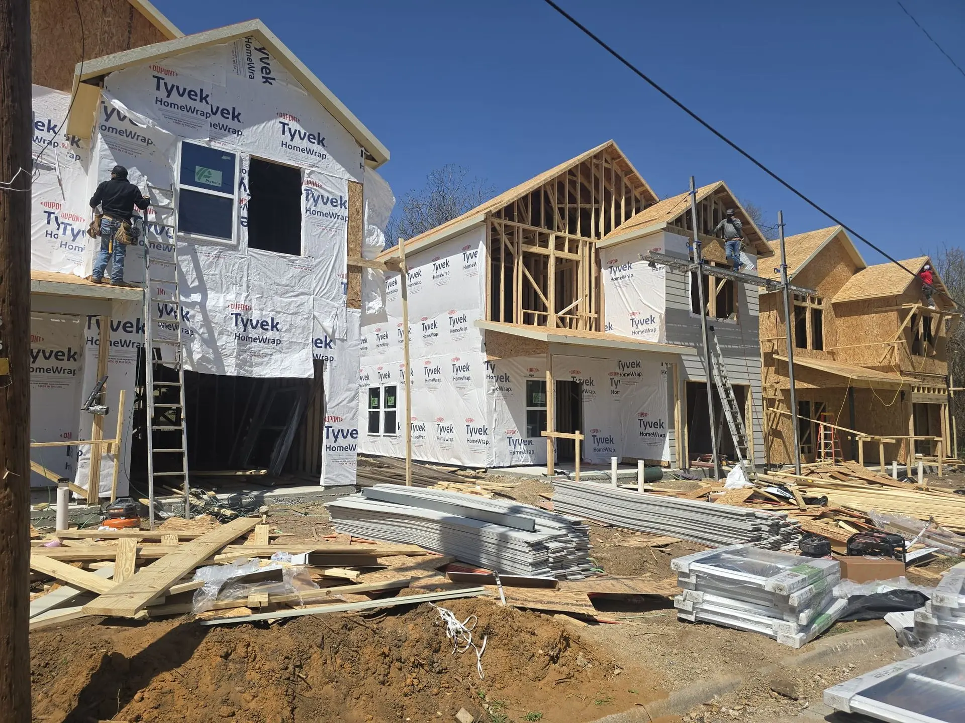 DFW multi-unit construction project with multiple homes framed and building materials delivered